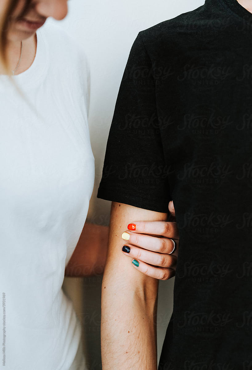 Close up of woman holding man with colorful nailpolish rainbow colors