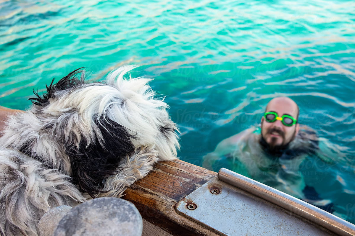 Man with googles coming on a boat after swimming in the sea