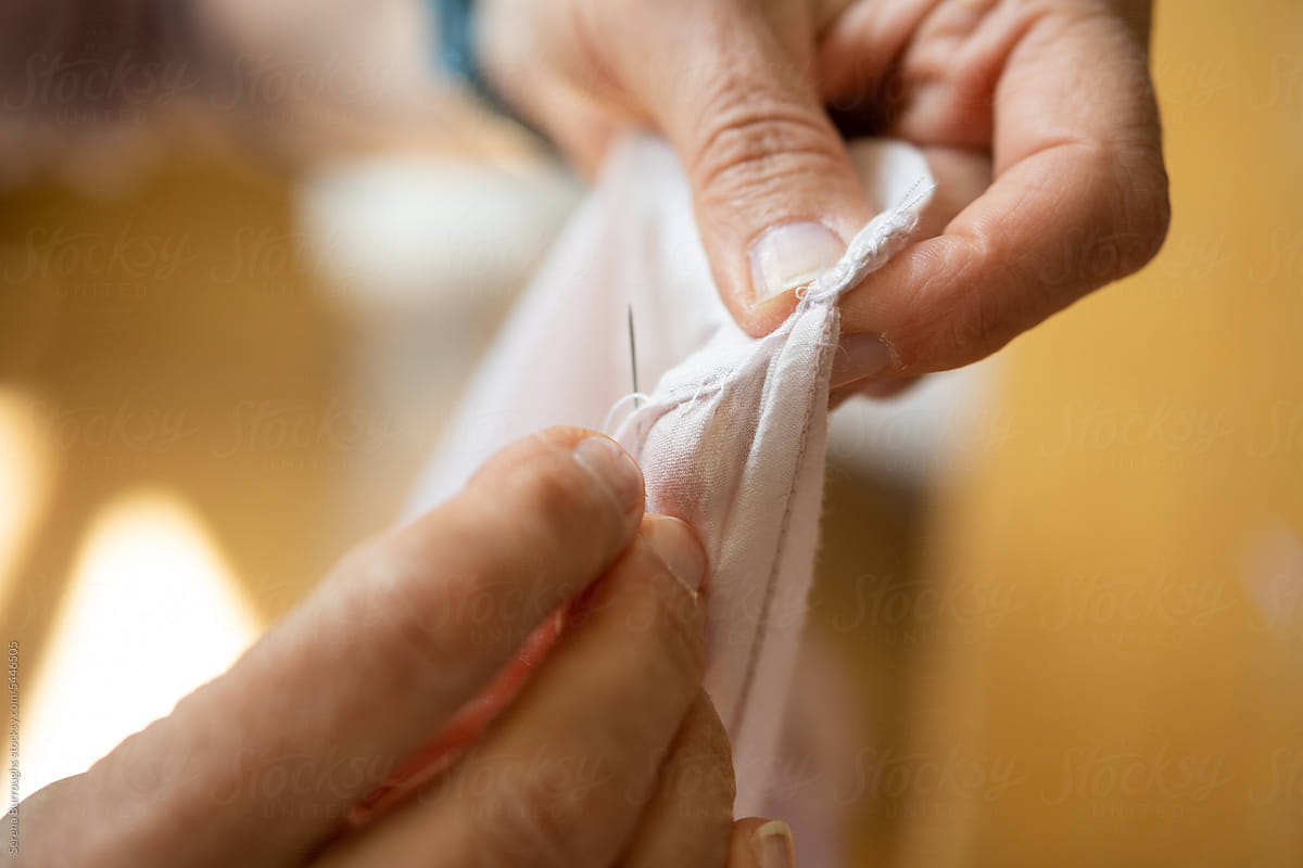 Middle Aged Woman Fixing Blouse with Needle and Thread