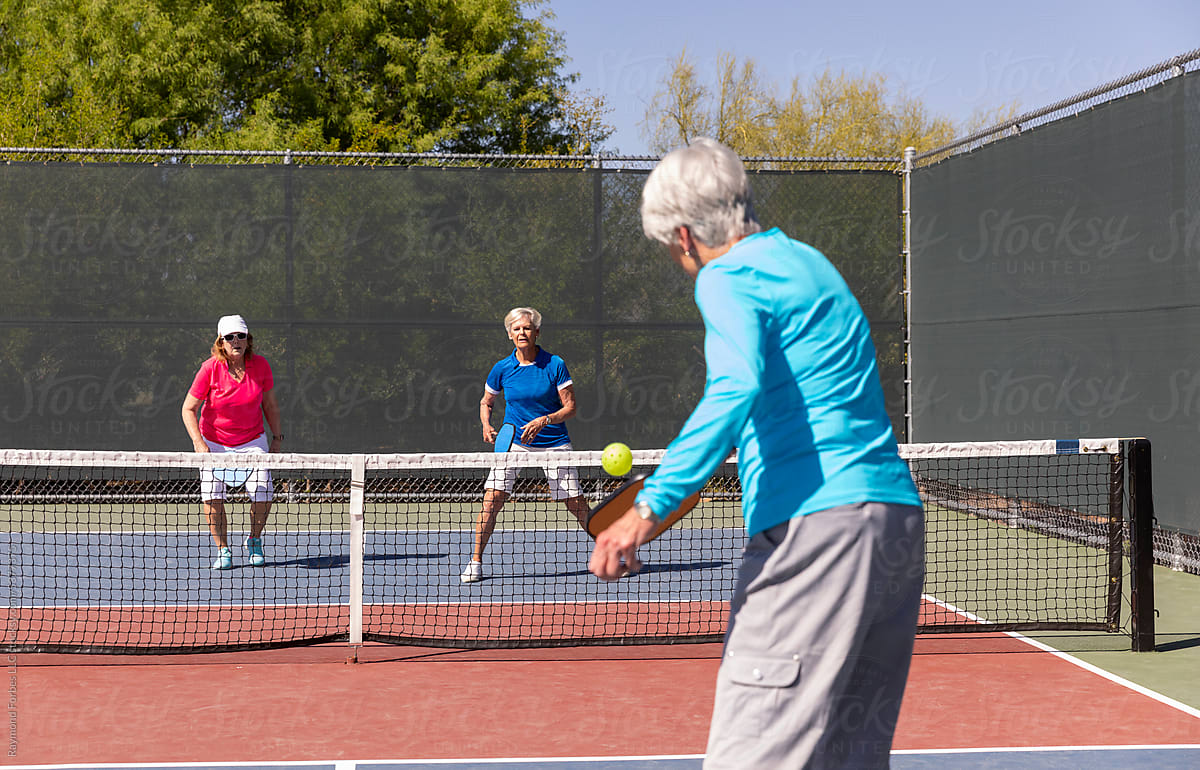 Senior Citizen teams playing match on Pickleball court