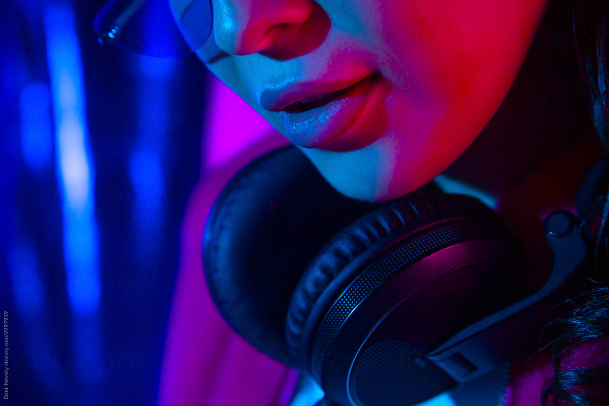 Young woman with headphones in neon light