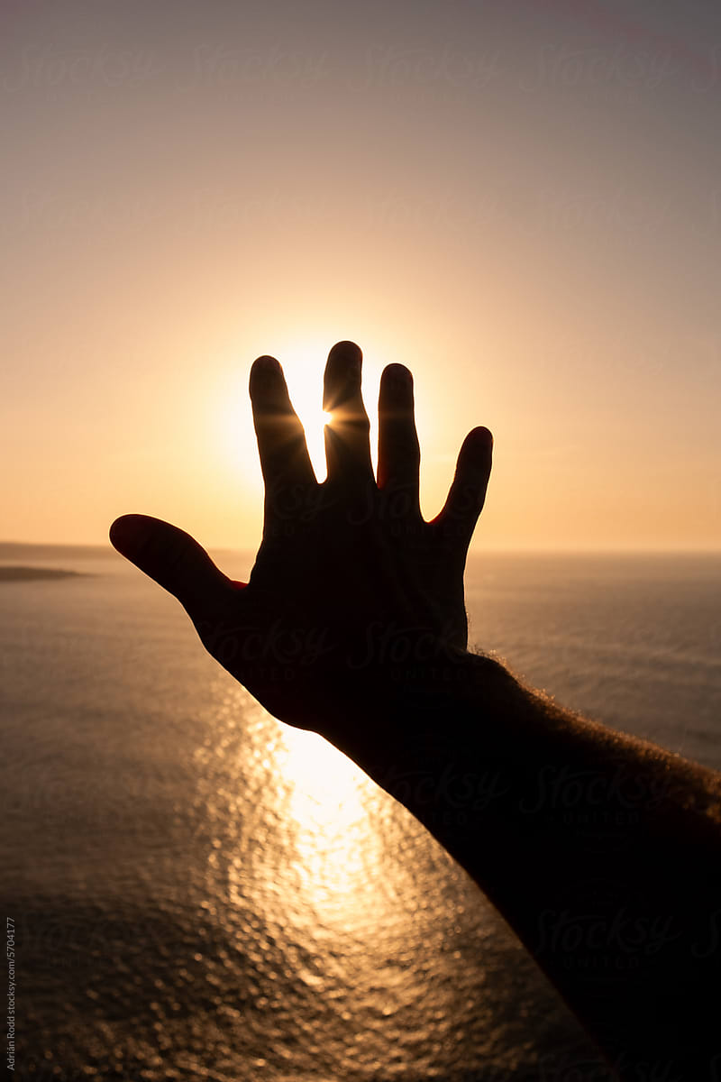 POV of a hand blocking out the sun representing the concept of freedom