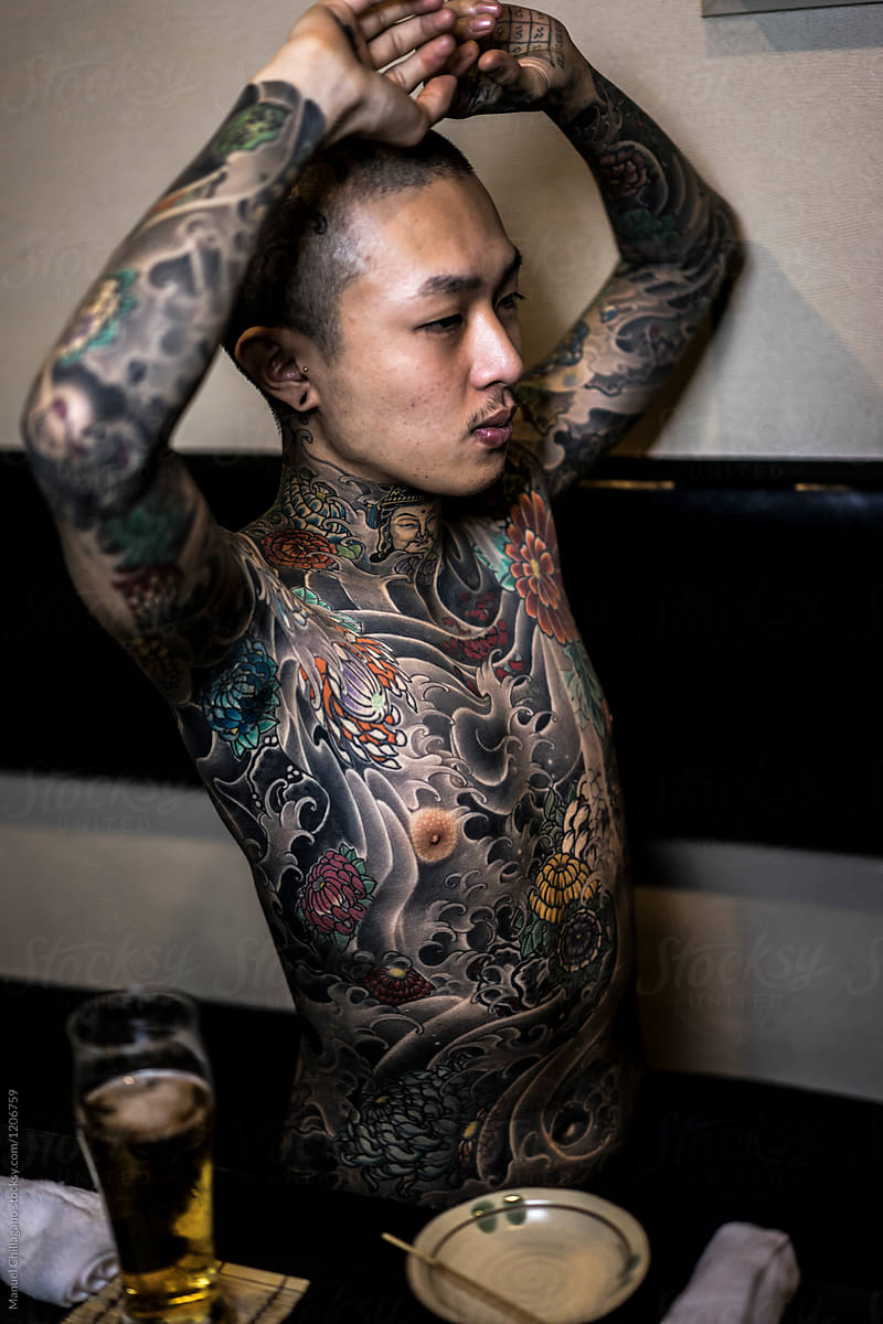 Young Japanese man exposing his tattoos in a Japanese bar