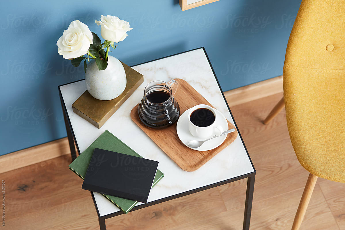 Top view of table with coffee, flowers and books.