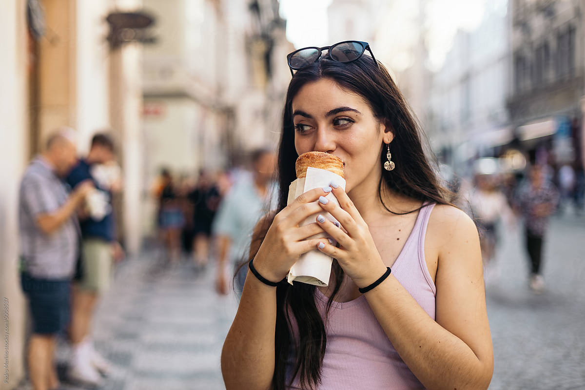 Woman eating a trdelnik in Prague