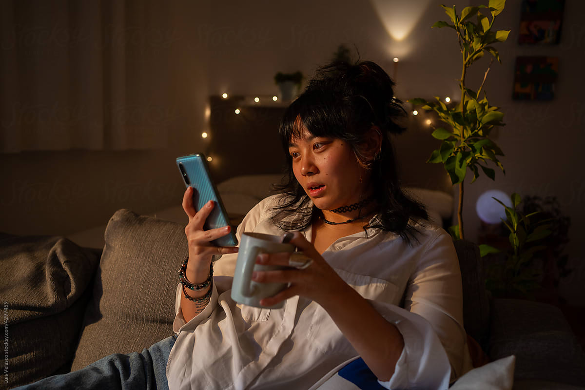 Girl On The Couch Having A Drink And Checking The Phone