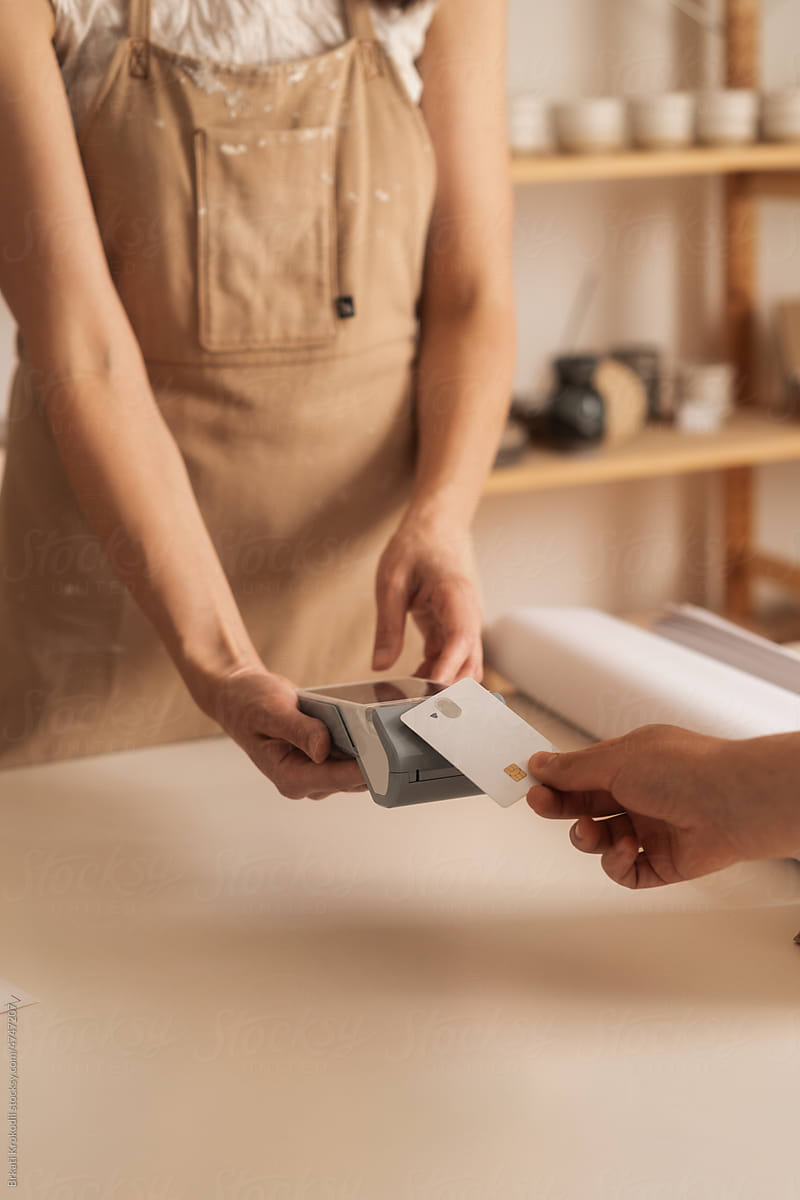 Anonymous Woman Holding A Credit Card Terminal For A Paying Customer