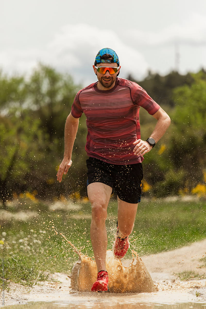 runner splashes on muddy track