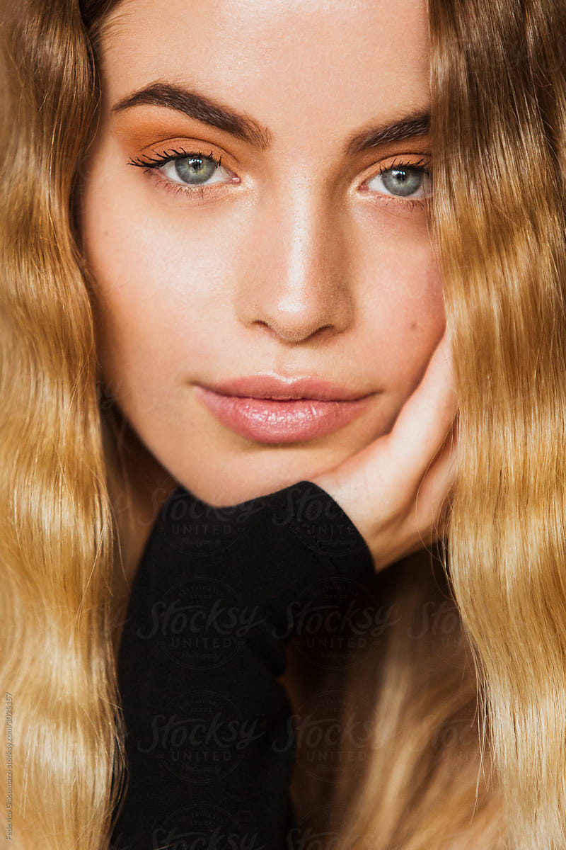 Portrait Of A Girl With Long Blonde Curly Hair Looking Straight Into