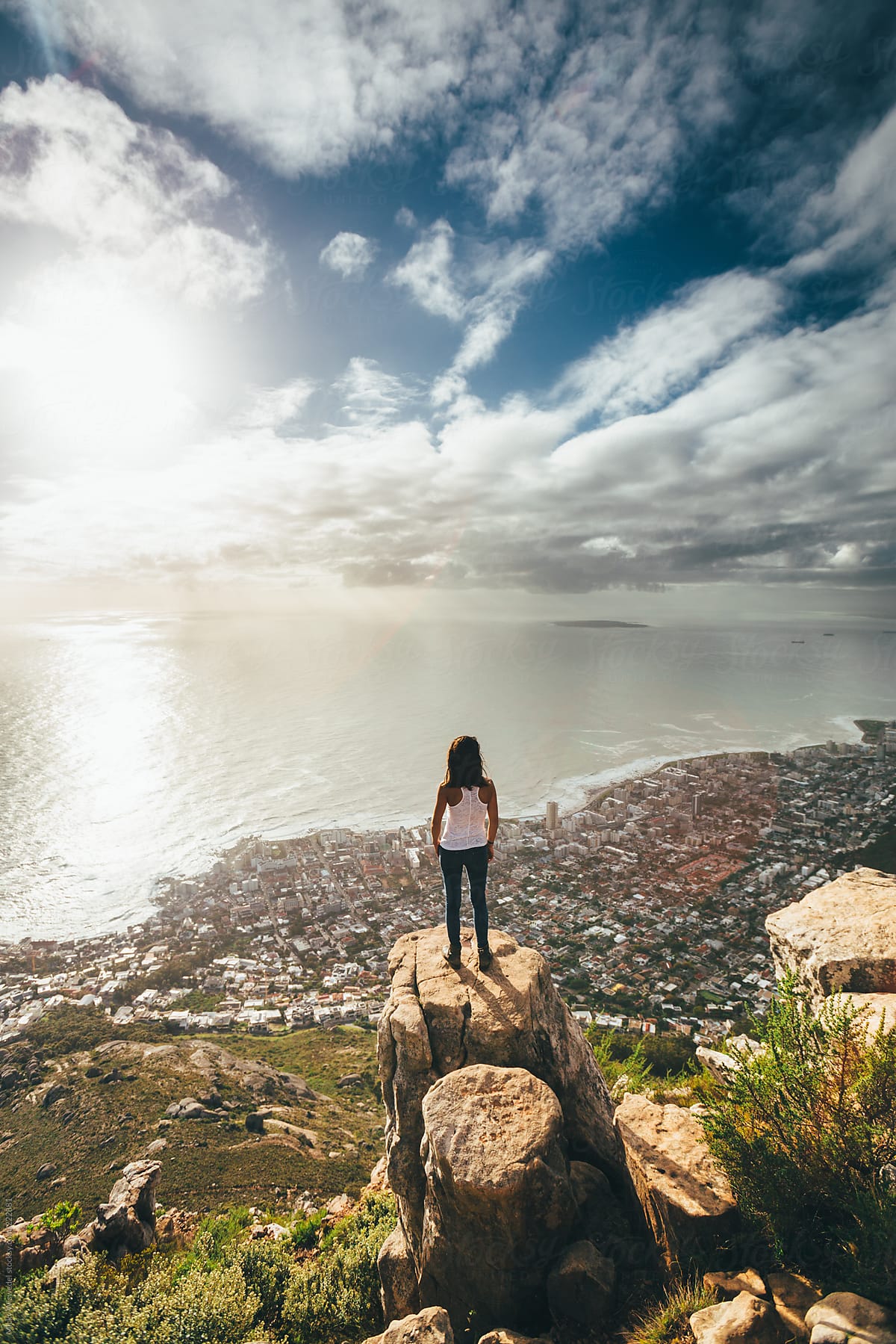 Woman standing on top of a mountain overlooking the city of Cape Town