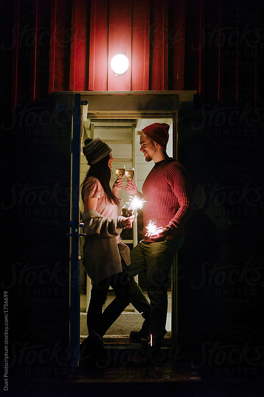 Loving couple with sparklers kissing at night