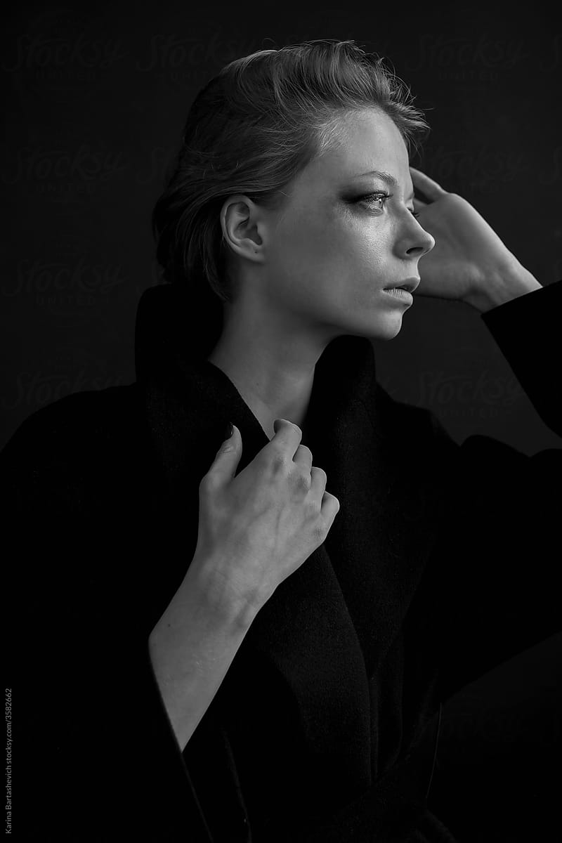 black and white portrait of an internally strong girl in a black coat in profile