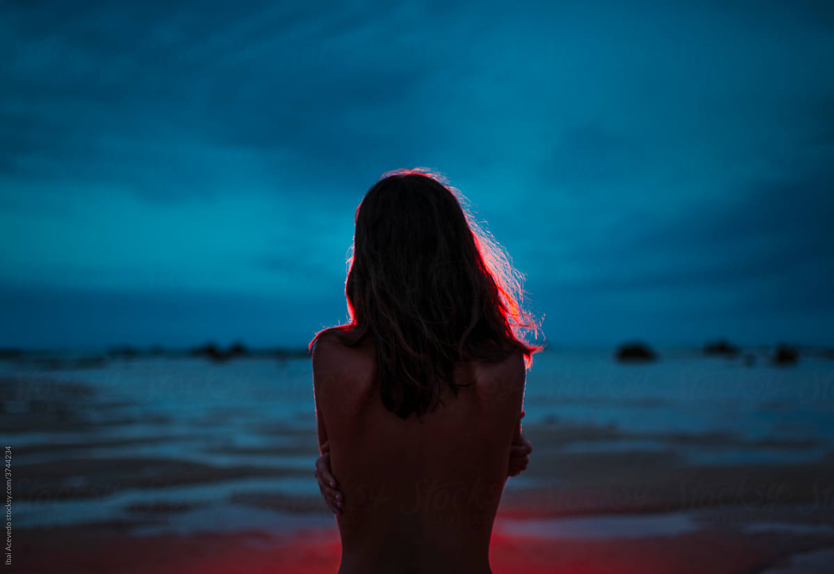Girl hugging herself in a dark beach