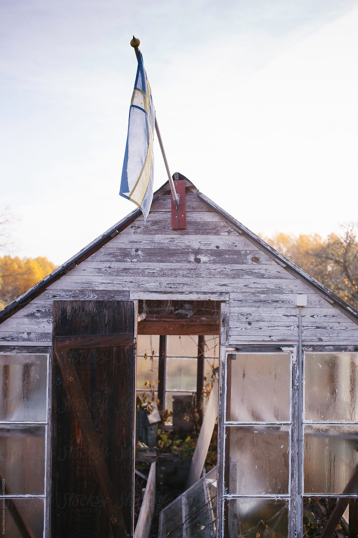 A small abandoned greenhouse with the Swedish flag