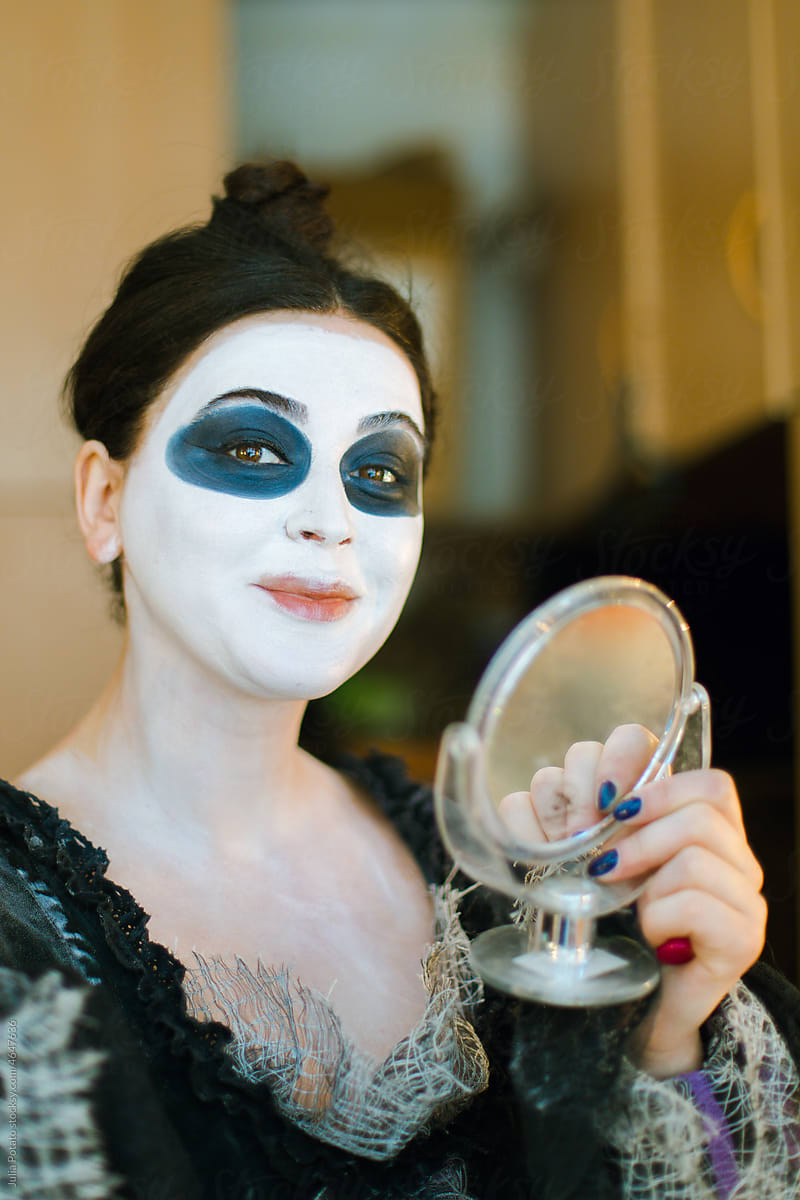 An actress  with small mirror makes her make-up
