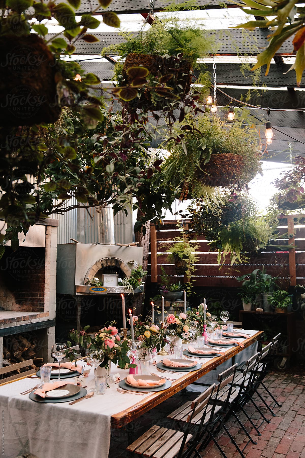 Fancy dinner table set up for a dinner party in a greenhouse