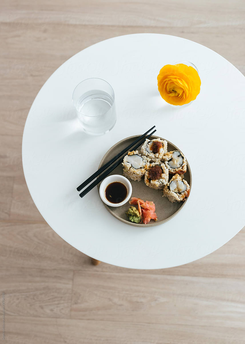 Spicy scallop sushi in ceramic plate on white table with chopsticks
