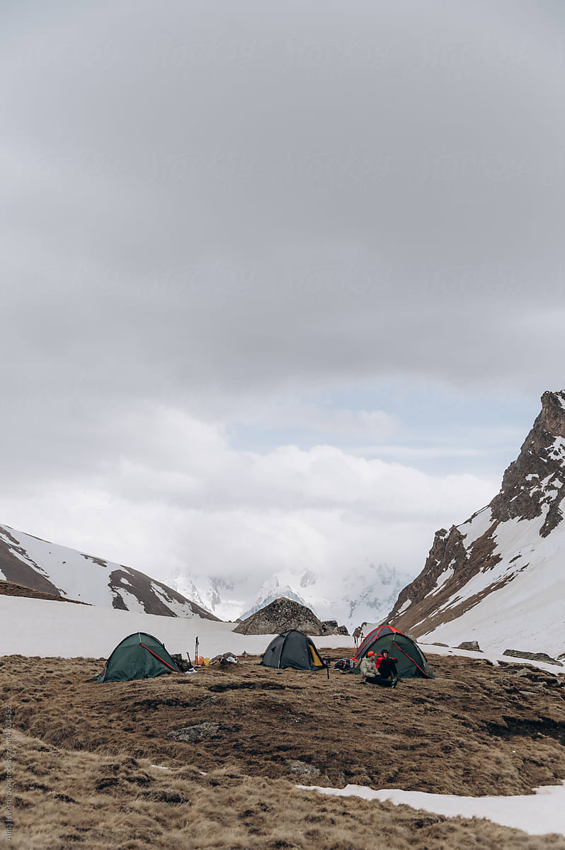 Hikers admiring snowy mountains from campsite