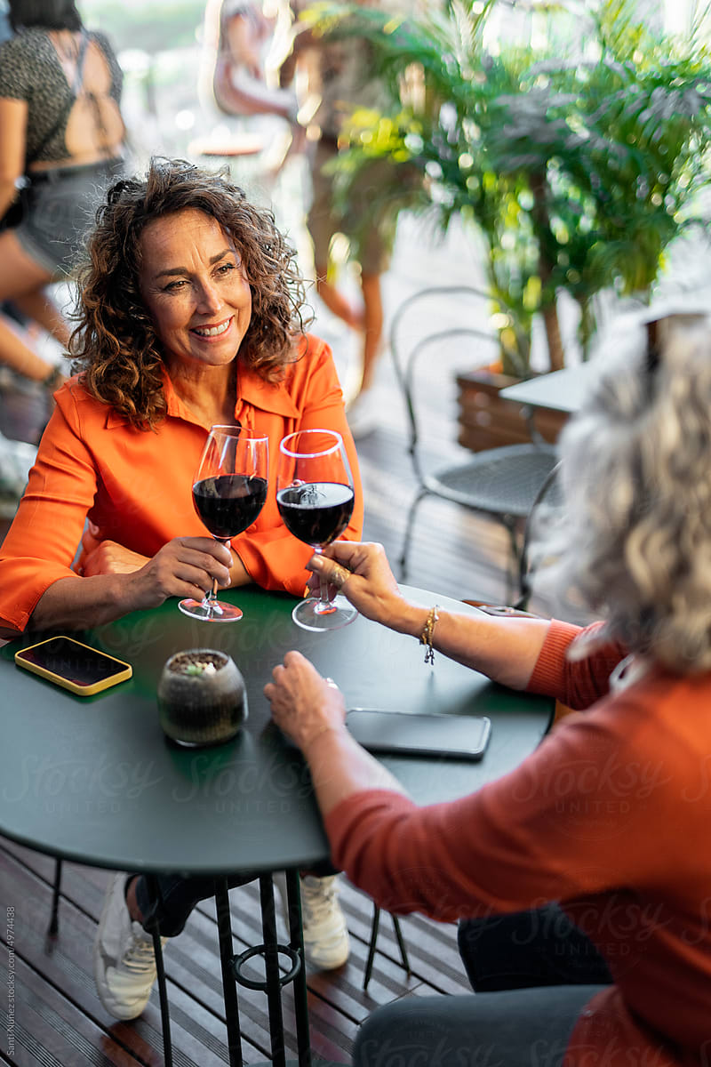 Happy senior women drinking wine on terrace
