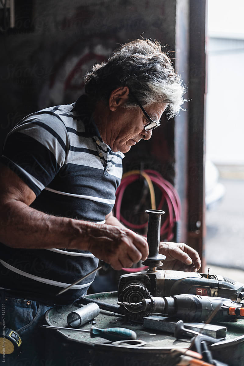 Older man repairing a machine