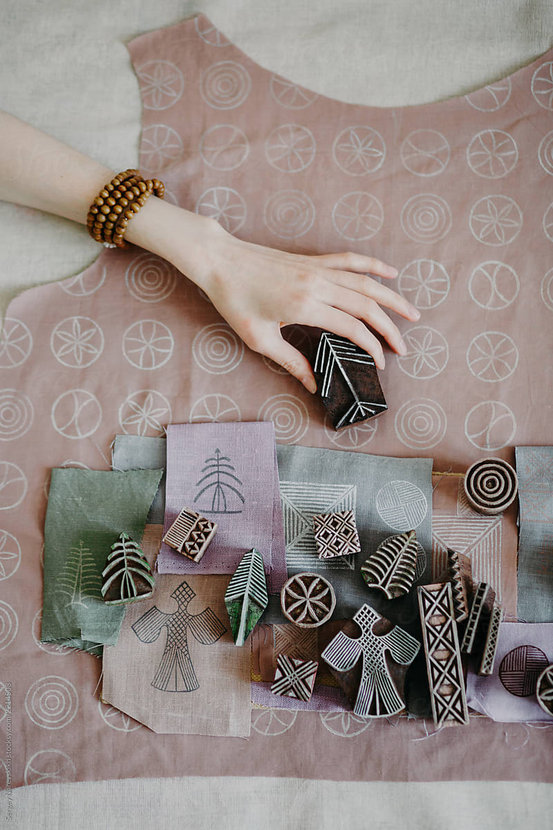 Hands of designer and stamps for fabric design