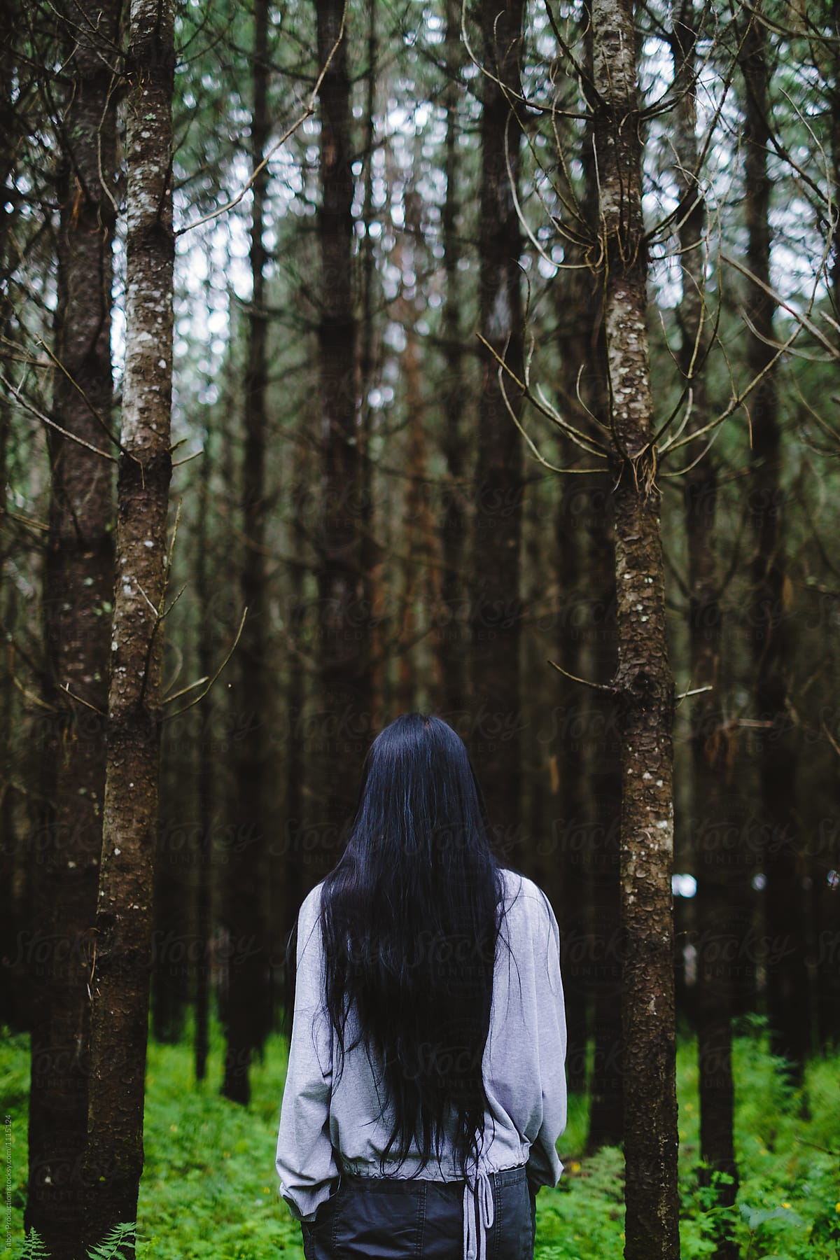 Young asian woman stands alone in the forest