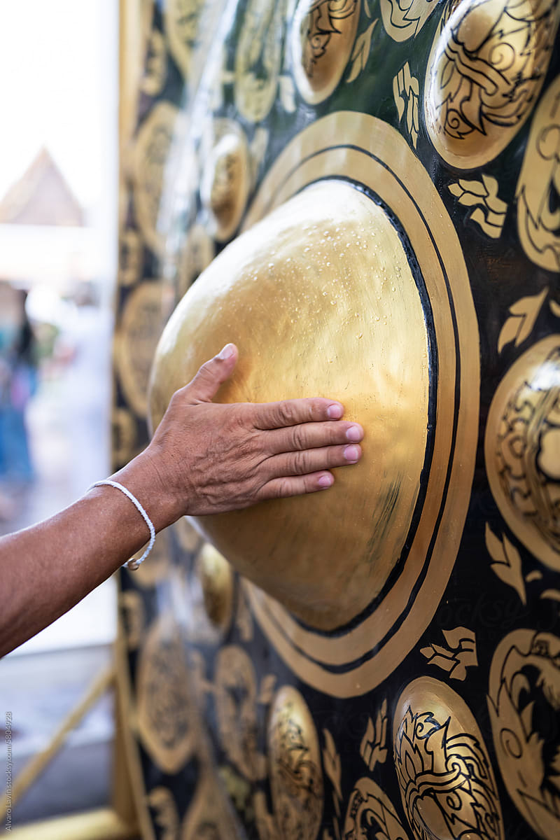 Close up of a hand touching gong.