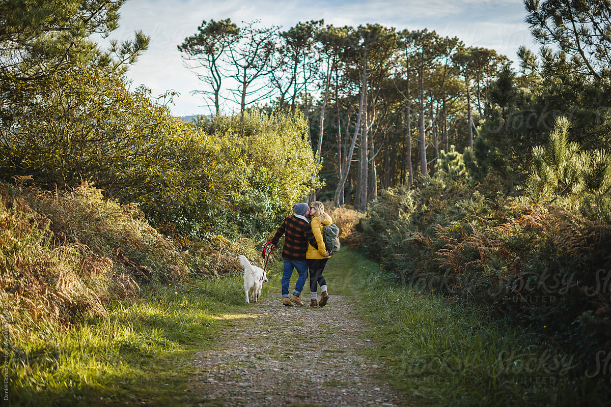 Loving couple with dog in forest