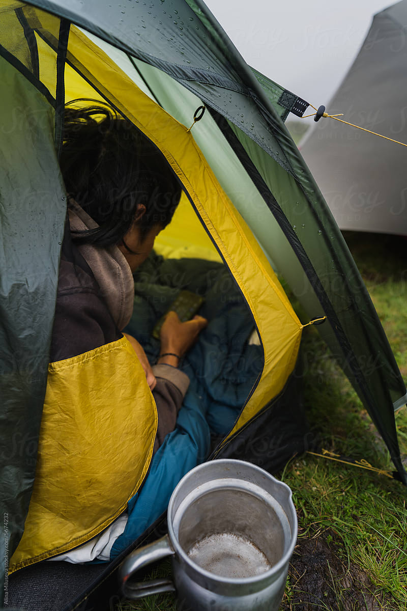 Young Traveler In A Tent With His Mobile Phone