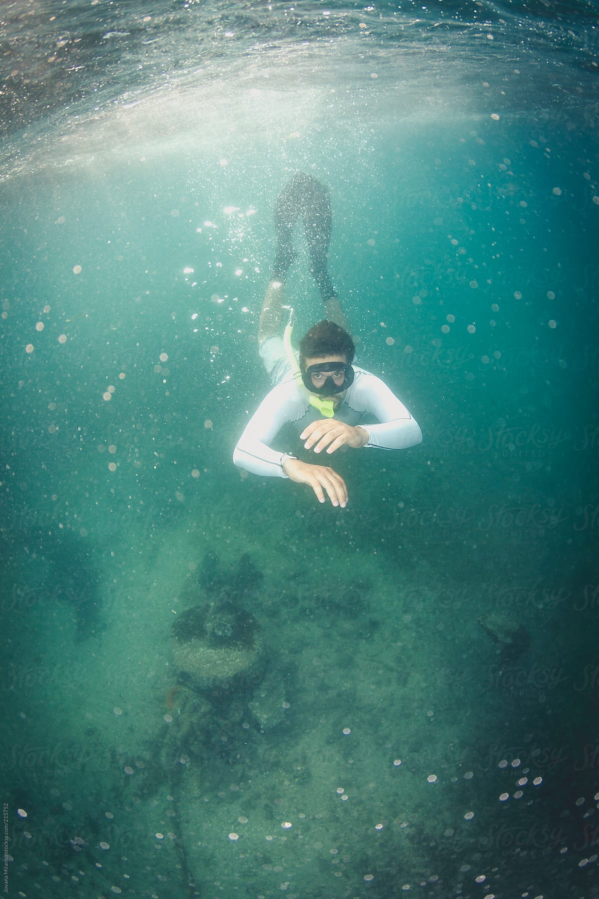 Snorkeler diving under the sea