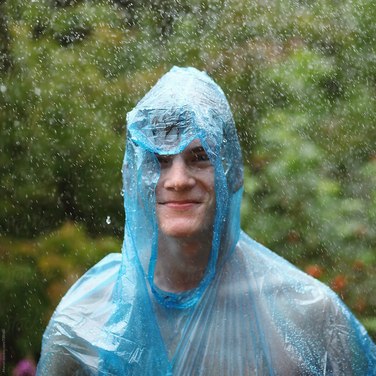 Young man at festival in pouring rain