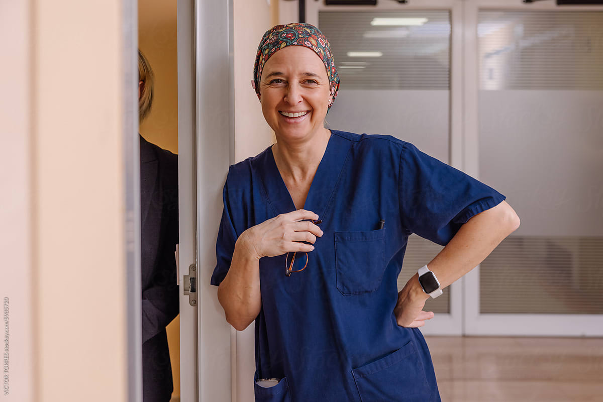 Confident female surgeon smiling in hospital corridor