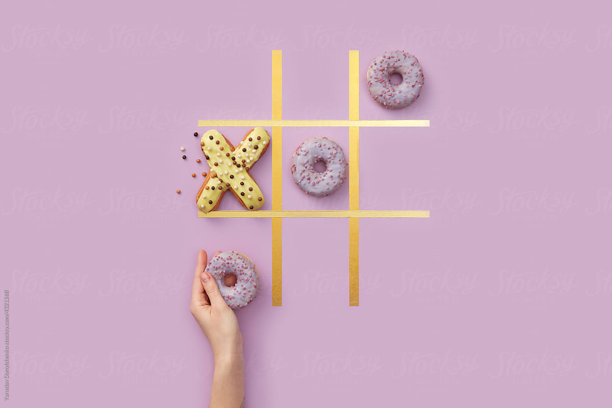 Woman playing tic-tac-toe game with donuts