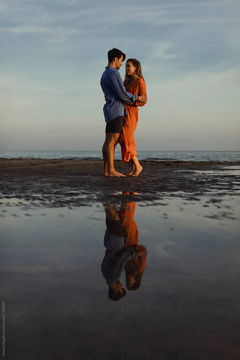 Couple embracing at the beach at sunset