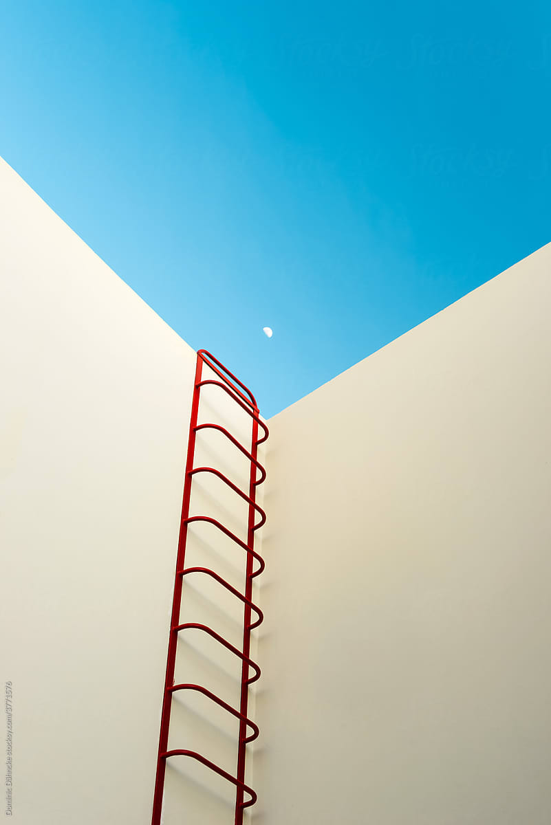 A red staircase to the moon on a facade.