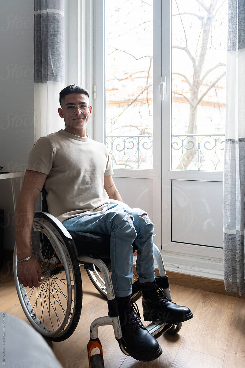 Portrait Of Young Man With A Disability At Home Looking At Camera.