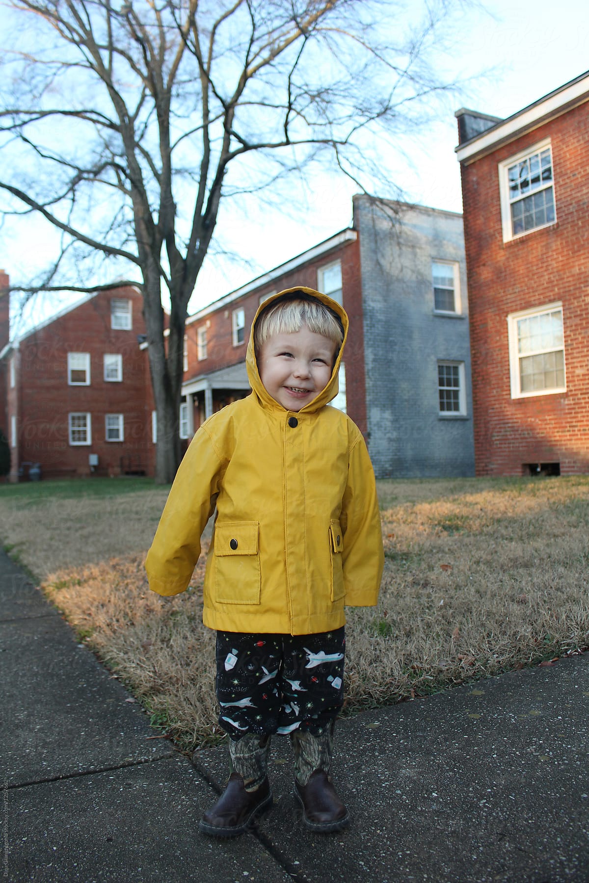 Blonde Toddler In Bright Rain Coat Outside