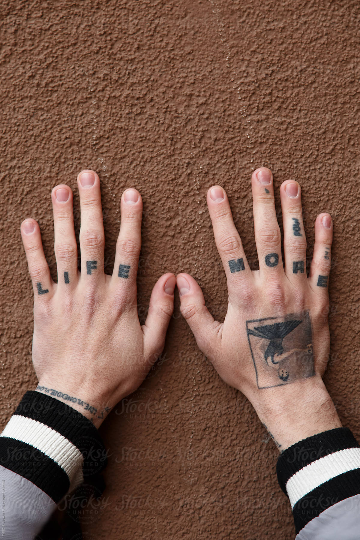 Tattooed hands on wall