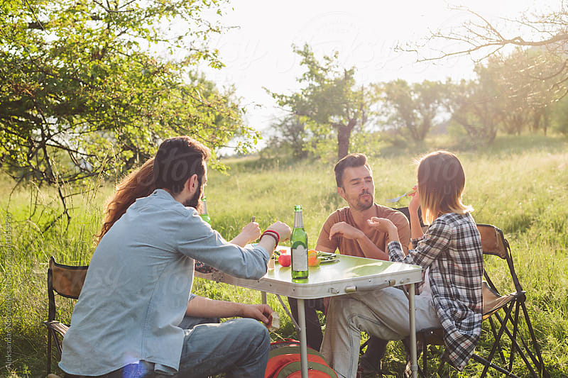 Group of friends eating and chatting outdoors