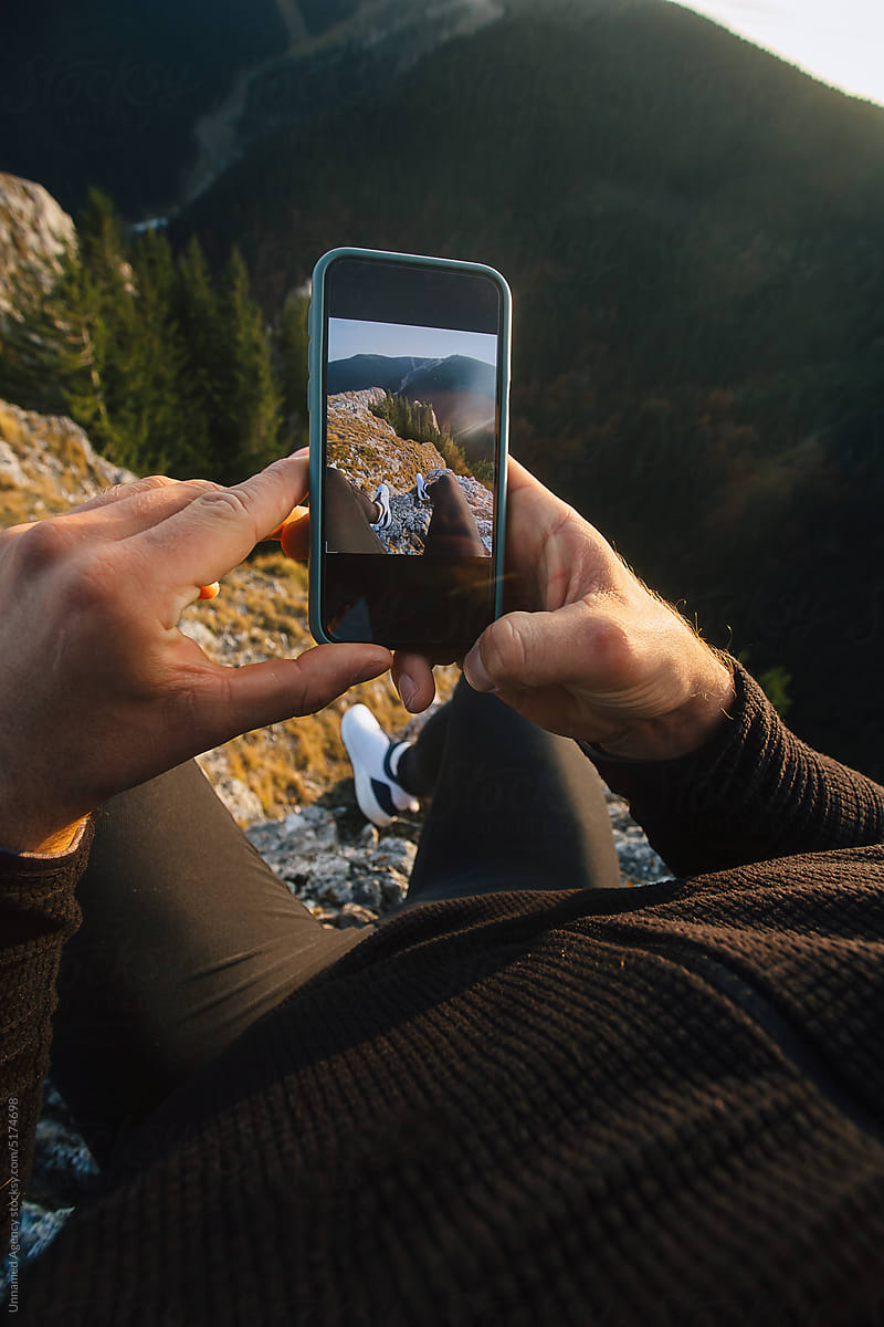 Taking a photo on a mountain cliff edge