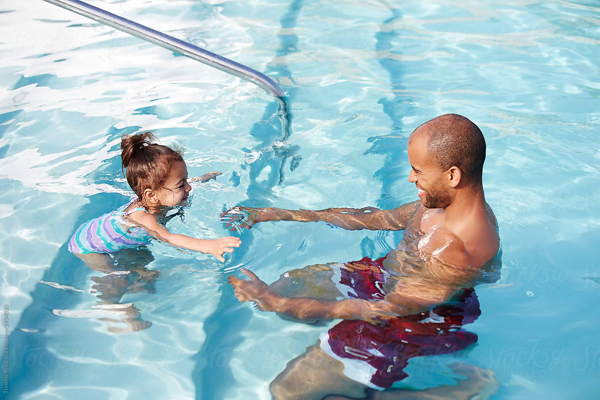 African American Father Giving His Daughter A Swim Lesson Del