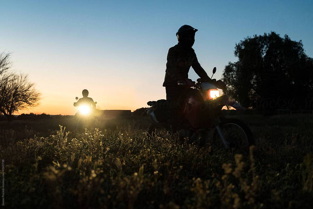 Two motorcycles riding through the wild after dark
