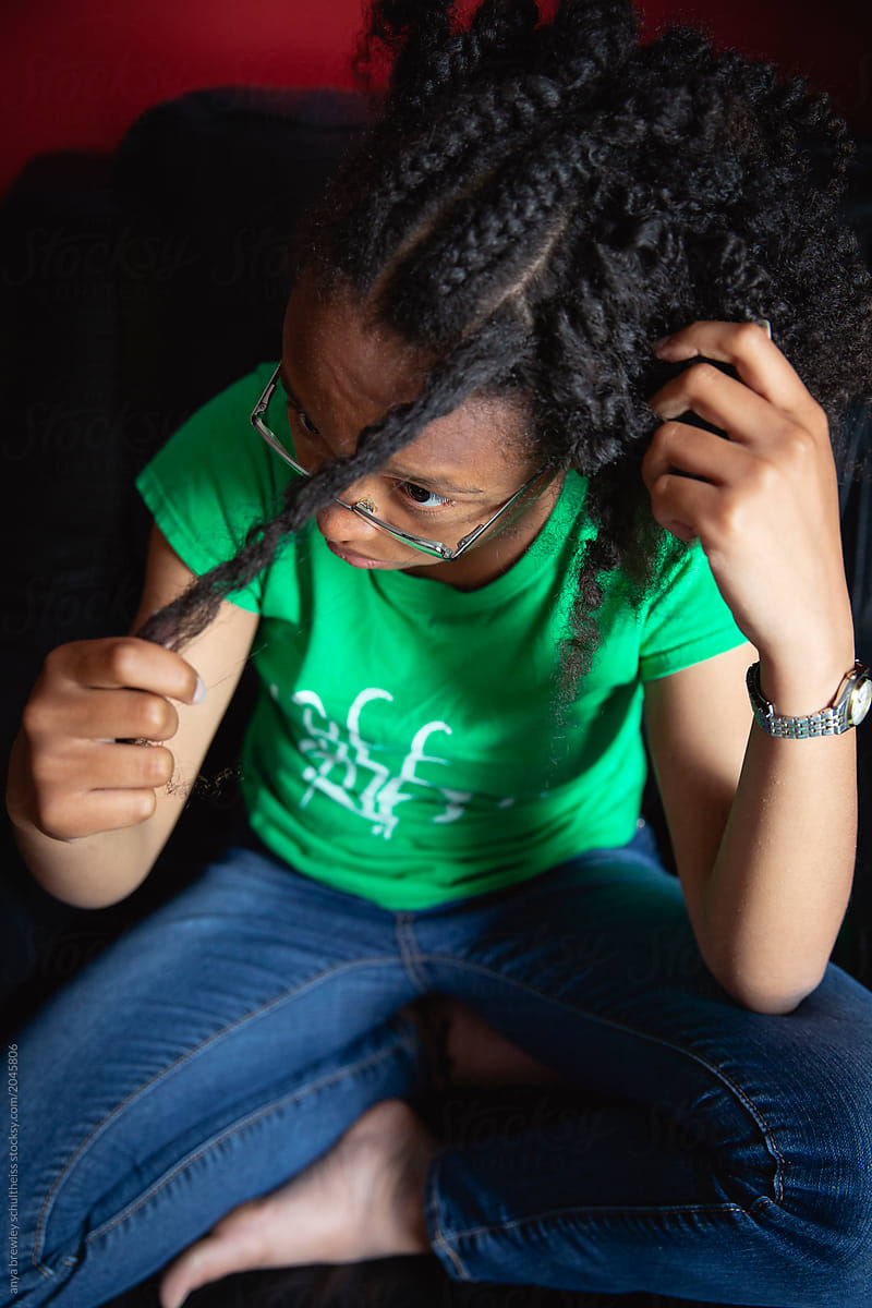 Teenager combing her kinky curly hair