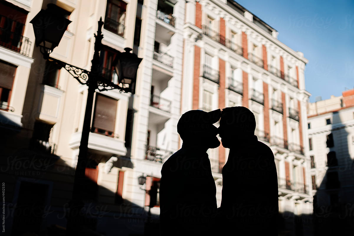 Couple of gay men kissing in city