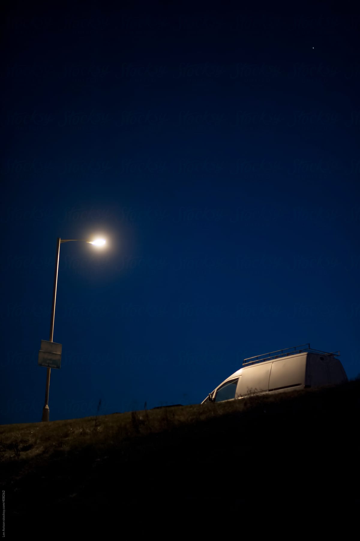 white van parked under a streetlight at night