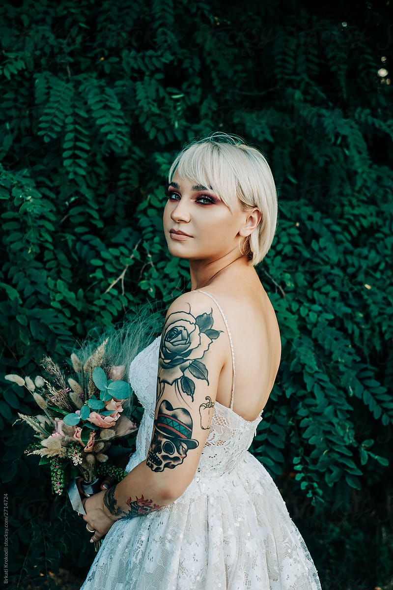 Portrait Of Beautiful Tattooed Bride With Bouquet