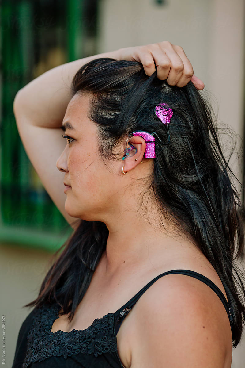Asian woman with pink cochlear implant