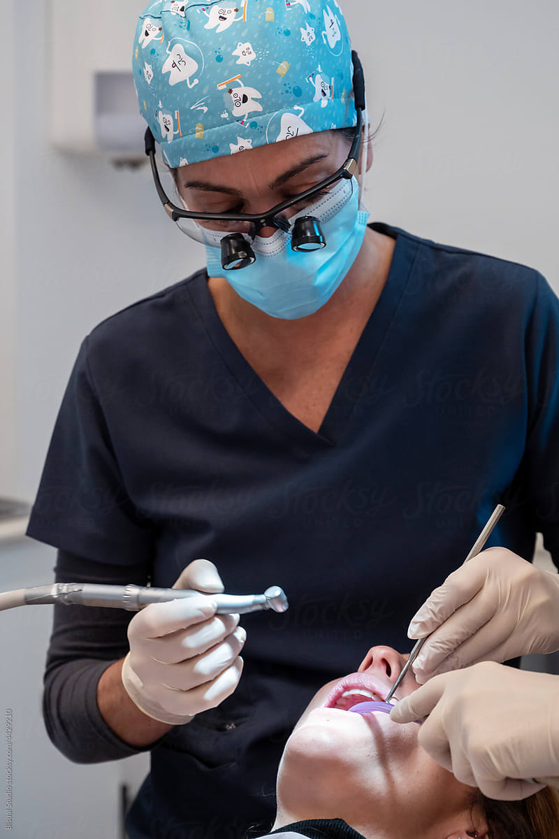 Orthodontist making a dental cleaning to patient