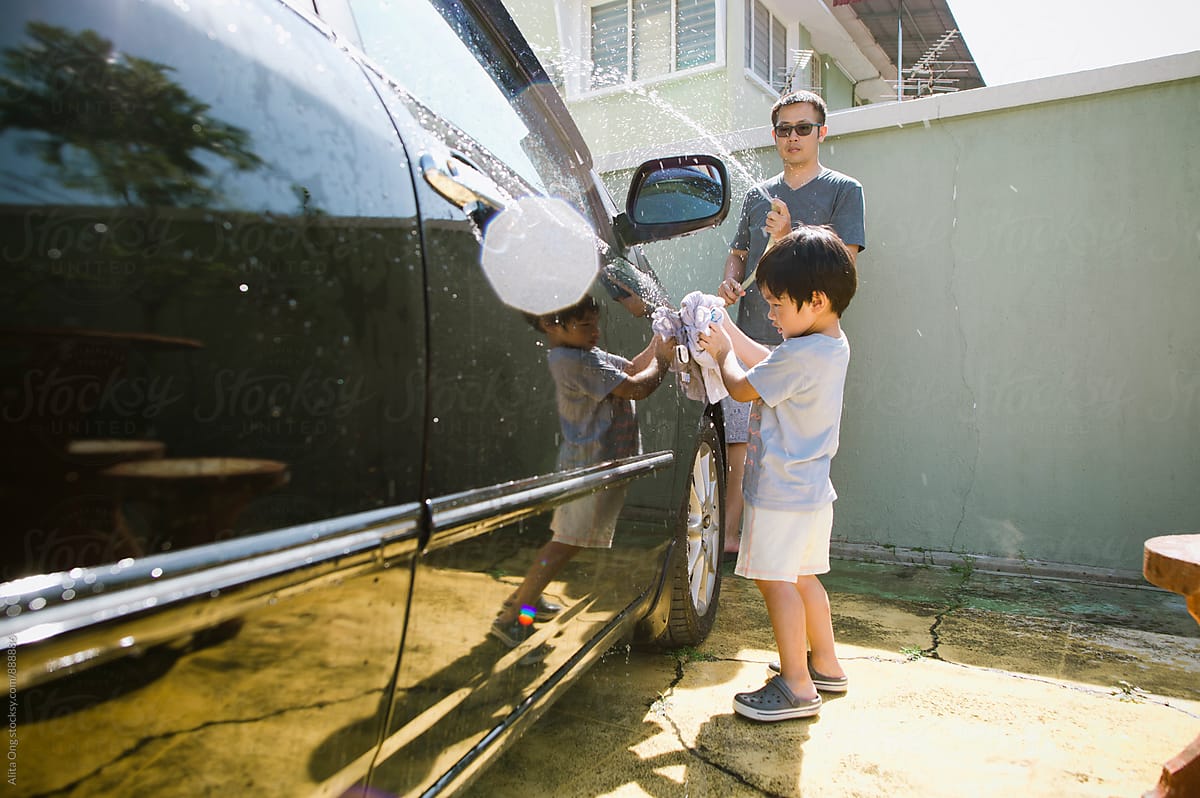 Little boy helping dad with car washing