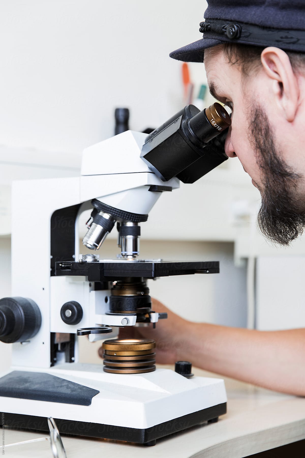 Young man looking through a microscope in a lab
